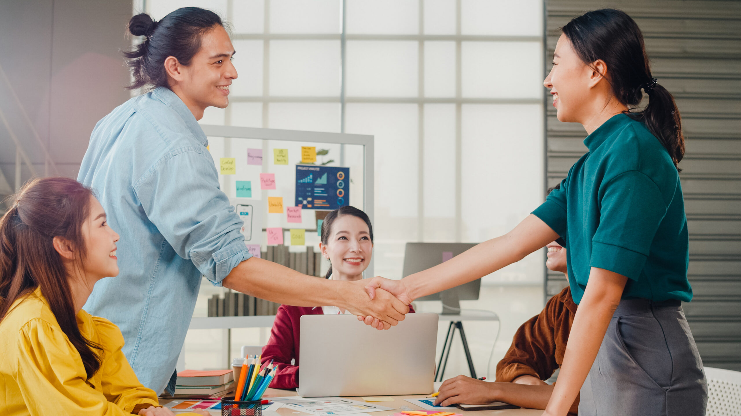 multiracial group young creative people smart casual wear discussing business shaking hands together smiling while standing modern office partner cooperation coworker teamwork concept scaled | Does Your Company Require GEO Employer of Record ?